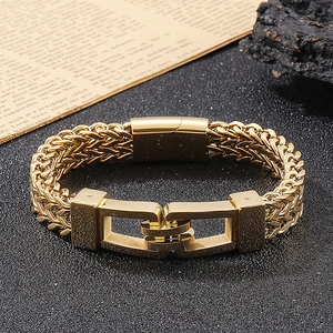 Close-up of golden stainless steel wheat chain bracelet with unique interlocking clasp