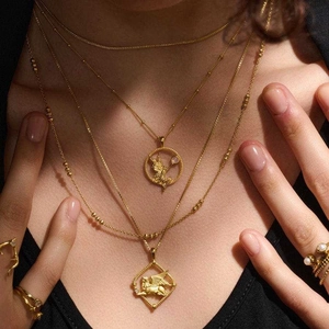 Gold plated Greek Goddess necklaces featuring Athena and Medusa pendants on a model