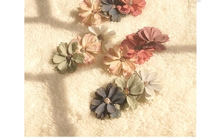 Detailed macro view of handmade fabric flower hair clips in vintage Morandi colors