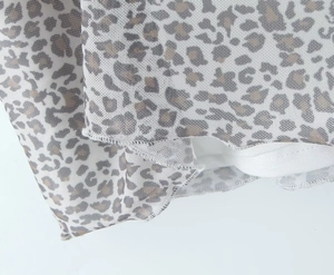 Nahaufnahme von Netzstoff mit Leopardenmuster, Textur und feiner Overlock-Naht