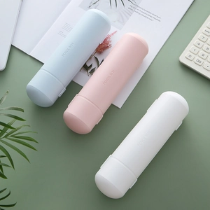 Minimalist cylindrical plastic pencil boxes in blue, pink and white on a desk