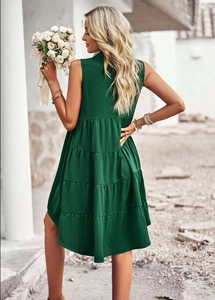 Détail d'une robe à étages sans manches vert foncé montrant le dos et l'ourlet fluide