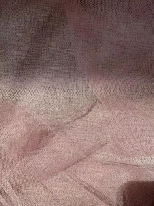 Detailed close-up of layered mesh fabric in dusty rose for a tiered maxi skirt