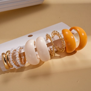Detail of 6-pair earring set featuring acrylic pearls, gold hoops and resin textures