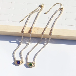 Gold tennis necklaces with sparkling green and blue evil eye zircon pendants on white board