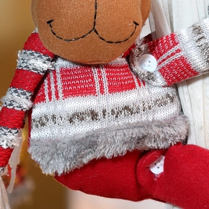 Macro detail of Christmas reindeer curtain tieback showing knitted wool and plush texture