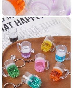 Gros plan de porte-clés chopes de bière colorés en résine avec mousse sur un plateau