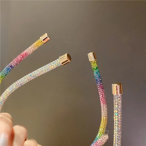 Detail of colorful gradient rhinestones and golden metal cap on the slim headband