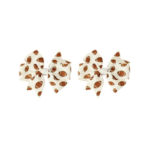 Pair of white grosgrain hair bows featuring brown rugby football print for children