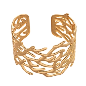 Golden open cuff bracelet featuring a detailed coral branch texture and geometric cutout design