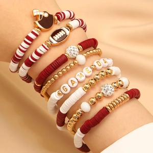 Close-up of stacked Game Day beaded bracelets with football helmet charm and burgundy heishi beads