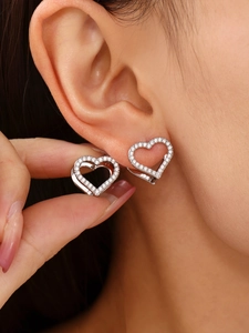 Close-up of heart-shaped silver earrings with micro-paved white zircon stones