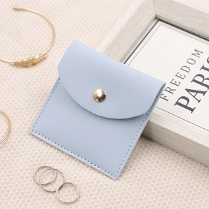 Macro detail of microfiber jewelry envelope pouch in light blue with gold snap button