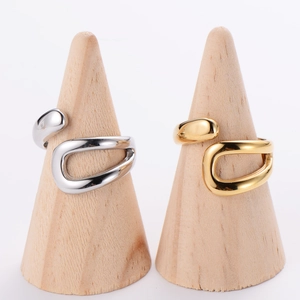 Infinity symbol open ring in gold and silver steel on wooden display cones