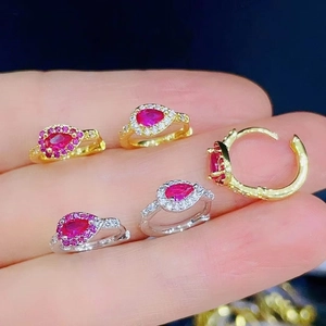 Macro view of gold and silver ear hoops with pink waterdrop stones and micro diamonds