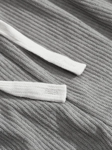 Macro shot of grey corduroy fabric texture and white braided drawstring detailing
