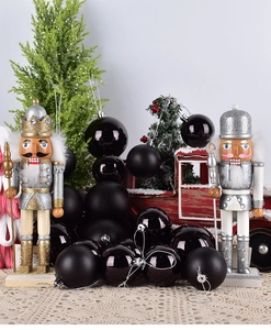 Glossy and matte black Christmas ornament balls with silver caps in a festive display