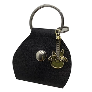 Macro shot of black leather guitar pick case with metal snap and golden guitar pendant
