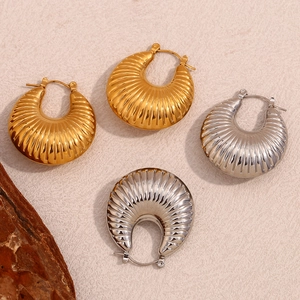 Detail showing 18K gold and silver crescent earrings with textured radiating stripes