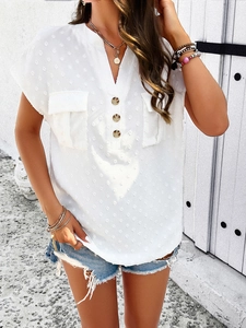 Detail of white V-neck blouse featuring jacquard polka dot texture and front pockets