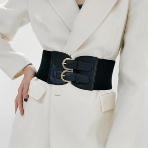Detail of wide black elastic waist belt with double gold buckles on a white blazer