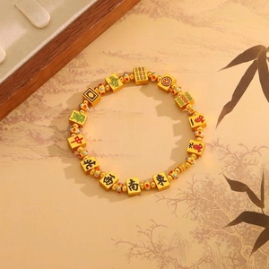 Golden mahjong bead bracelet with Chinese characters on traditional landscape background