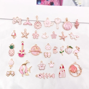 Flat lay of pink enamel charms including stars shells and flowers for DIY jewelry making
