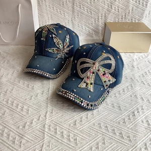 Detail of denim baseball caps with rhinestone hemp leaf and bow patterns and silver studs