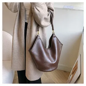 Detail of vintage coffee brown leather tote with V-shaped fold and thick round handle