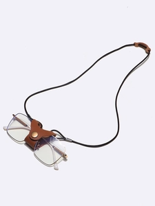 Detail of dark brown leather eyewear strap with metal snap button and sturdy black cord