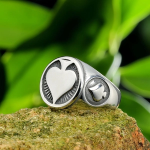 Detailed macro view of silver spade ring with engraved poker patterns on stainless steel