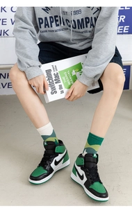 Street style shot of green and black high-top sneakers paired with geometric pattern crew socks