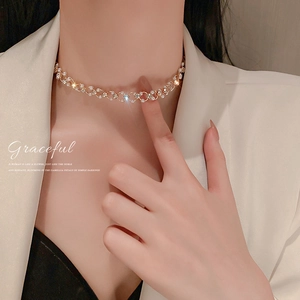 Gros plan d'un collier ras du cou doré avec perles et strass sur un mannequin femme