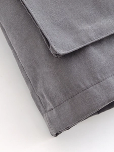 Macro shot of dark grey high-density twill fabric with precision double stitching details