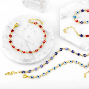 Detalle de pulseras de ojo turco bañadas en oro con acabado de esmalte rojo y azul