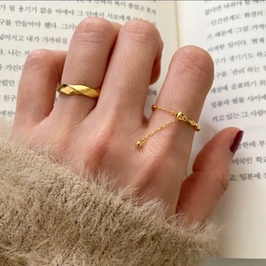 Detail of 925 sterling silver olive bead rings set in gold finish worn on fingers