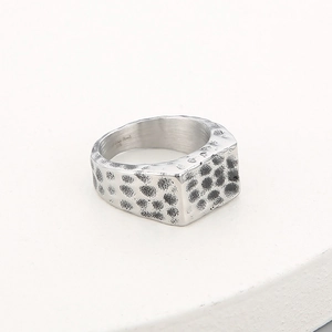 Detail of vintage hammered texture on wide stainless steel rectangular ring for men
