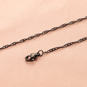 Detail van een zwarte 18K roestvrijstalen golfketting met een stevige karabijnsluiting