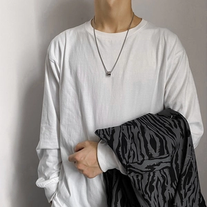 Unisex titanium steel cylinder pendant necklace on white long sleeve shirt