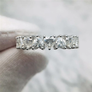 Macro shot of silver ring with heart-cut clear zircons in a delicate claw setting