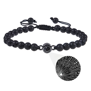 Detail eines verstellbaren Vulkansteinarmbands mit 100 Sprachen Projektionsanhänger