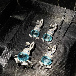 Macro detail of silver rabbit jewelry set with blue topaz and pavé crystals