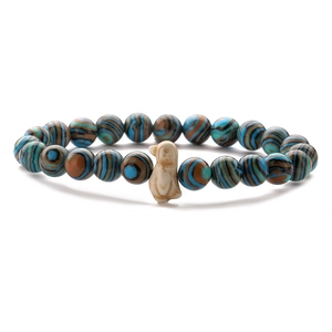 Detail of tiger eye and agate bead bracelet with a cream-colored animal charm