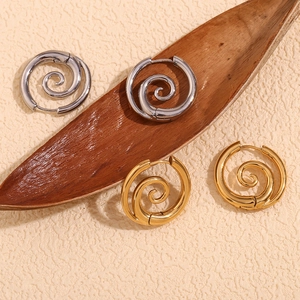 Detaillierte Nahaufnahme vergoldeter und silberner Spiral-Ohrringe auf einer Unterlage