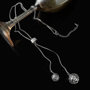 Detail of silver long Y-necklace with hollow sphere pendants and rhinestone slider