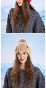 Detail of a women's winter knit beanie with soft pompom and ear protection in snow scenery