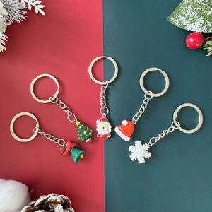 Christmas keychain set with Santa Claus, tree, bells and snowflakes on festive background