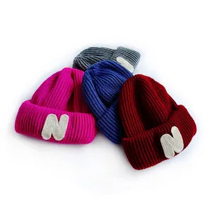 Set of colorful kids knit beanies with N letter patch in pink, blue, red and grey