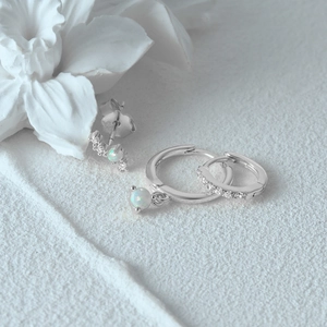 Three-piece S925 silver earring set with opal and zircon on white textured background