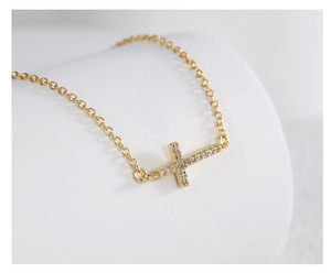 Detailed macro view of a sideways cross necklace with micro-pave cubic zirconia crystals